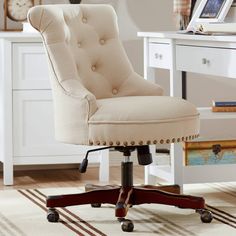 an office chair sitting on top of a wooden floor in front of a white desk