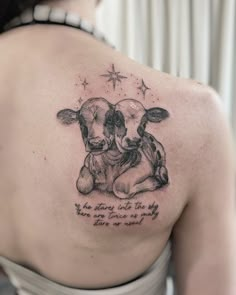 a woman with a tattoo on her shoulder has a cow hugging it's head