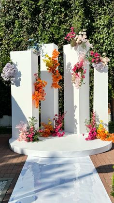 an outdoor wedding ceremony with flowers on the altar