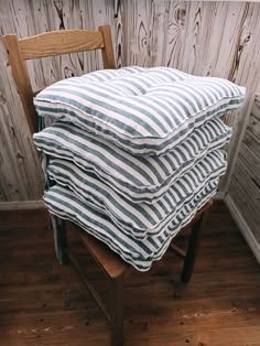 a stack of pillows sitting on top of a wooden chair