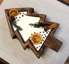 two slices of oranges and cinnamon on top of a cutting board with pine cones