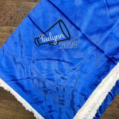 a blue graduation cap with the name and year on it sitting on top of a wooden floor