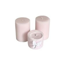 two pink candles with white bows on the top and one candle in the middle, sitting next to each other