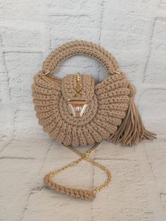 a handbag with a tasselled handle and gold chain hanging from the front