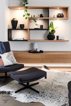 a living room with a chair, ottoman and shelves