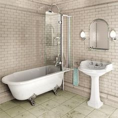 a white bathtub sitting next to a sink under a mirror in a tiled bathroom