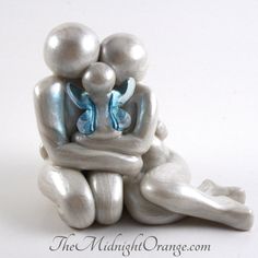 a ceramic figurine sitting on the ground with two balls in it's lap