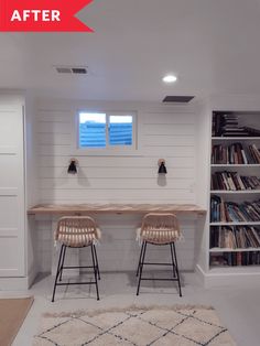 two chairs sitting in front of a counter with bookshelves behind them and a rug on the floor