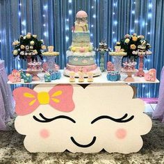 a table topped with a cake covered in frosting and a pink bow on top of it