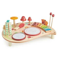 a wooden play table with musical instruments on it's sides and mushrooms in the background