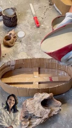 a woman is making a boat out of cardboard and some other items on the table