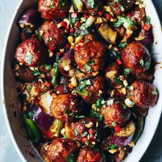 a white bowl filled with meatballs and vegetables