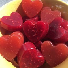 a yellow bowl filled with lots of red hearts