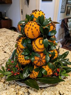 oranges are stacked on top of each other with leaves and berries all over them