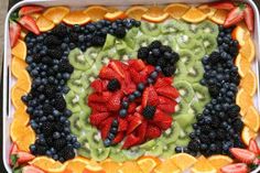 a square shaped fruit platter filled with kiwis, oranges, and strawberries