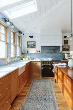 a kitchen with wooden cabinets and an area rug in front of the stove top oven