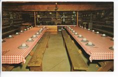 an old fashioned dining room with long tables and checkered tablecloths on them