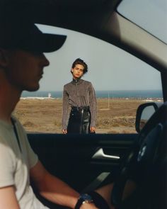 a man sitting in the driver's seat of a car next to a woman