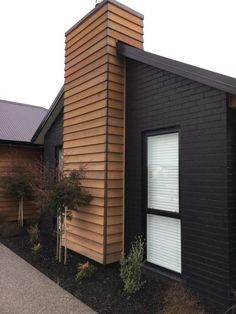 a black and brown house with white windows