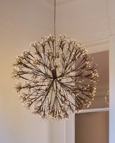 a chandelier hanging from the ceiling in a room with white walls and wood flooring