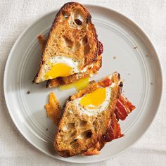 two pieces of bacon and egg toast on a white plate