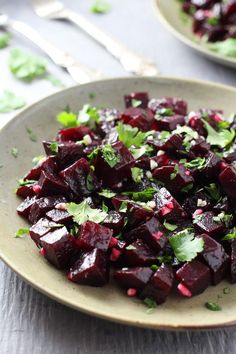 a white plate topped with beets and cilantro