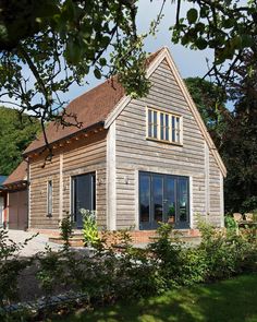 a large wooden house sitting on top of a lush green field