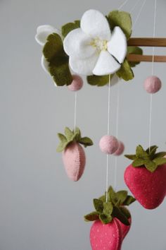 a mobile made out of felt with strawberries and flowers hanging from it's sides