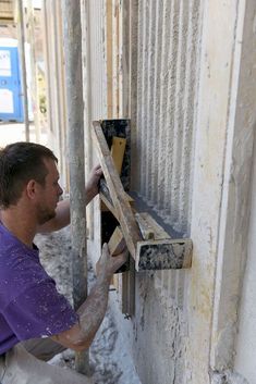 a man is working on the side of a building