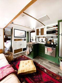 a living room and kitchen with green cabinets, pink rugs and an area rug on the floor