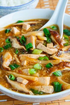 a close up of a bowl of soup with chopsticks sticking out of it