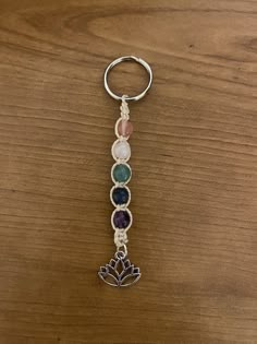 a key chain with seven chakras hanging from it's center on top of a wooden table