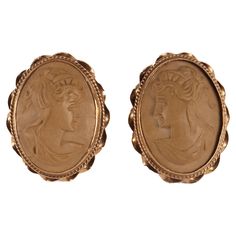 Gold and lava earrings. The oval cameos, sculpted in light lava, depict two profile busts of young women with classic hairstyles on a smooth background. The 14 kt gold setting features a smooth vertical bezel, decorated with a filigree ring and then completed with a helical motif with larger spirals. On the back two vertical bars have a pin and closure. Italy circa 1880. Luxury Vintage Lab-created Ruby Jewelry, Antique Gold Oval Cabochon Brooches, Vintage Oval Gold Cabochons, Ancient Greek Jewelry 1stdibs, Lava Earrings, Vintage Bronze Coin-shaped Jewelry, Vertical Bar, Classic Hairstyles, Filigree Ring