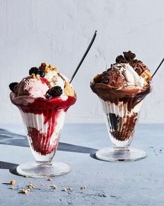 two ice cream sundaes with chocolate and berries