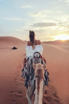 a woman riding on the back of a camel