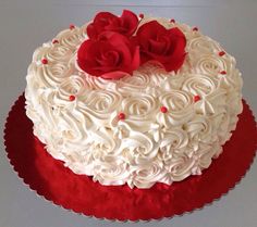 a white and red cake with roses on top