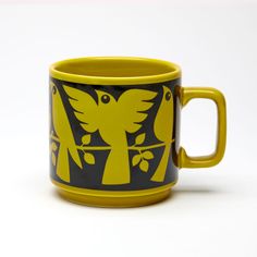 a yellow and black coffee cup sitting on top of a table