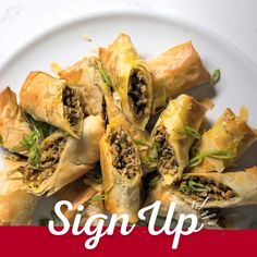 a white plate topped with pastries covered in meat and veggie toppings