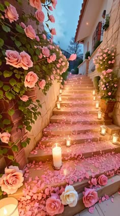 the steps are decorated with pink roses and lit candles for a romantic wedding or special event