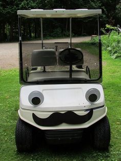 a white golf cart with a mustache on it