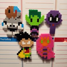 four perler beads are hanging on the wall