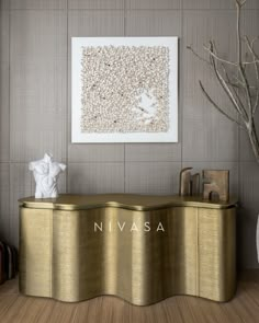 a gold console table in front of a painting on the wall