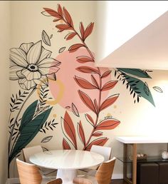 a white table and chairs in front of a floral wall mural