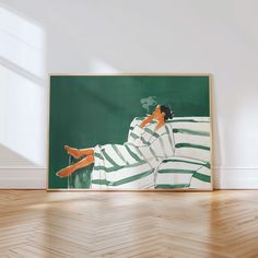 a painting is sitting on the floor in front of a white wall and wooden floors