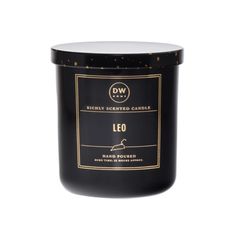 a candle that is black with gold dots on the lid and in front of a white background