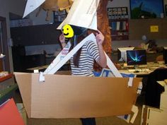 a woman holding a cardboard box with a smiley face on it and an umbrella over her head