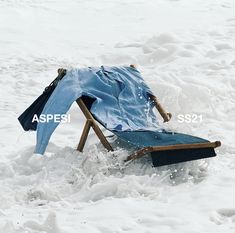 a chair that is in the snow with it's cover over its head and legs