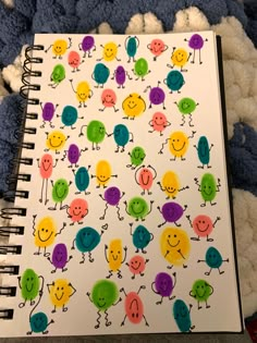 an open notebook with lots of different colored smiley faces on it