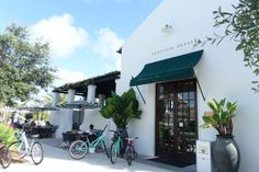 two bicycles parked outside the front of a restaurant with people sitting at tables and eating