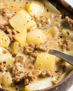 a bowl filled with meat and potatoes on top of a table